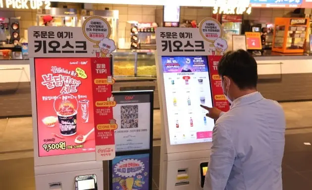 Customer ordering coffee on a Korean cafe kiosk with English language option