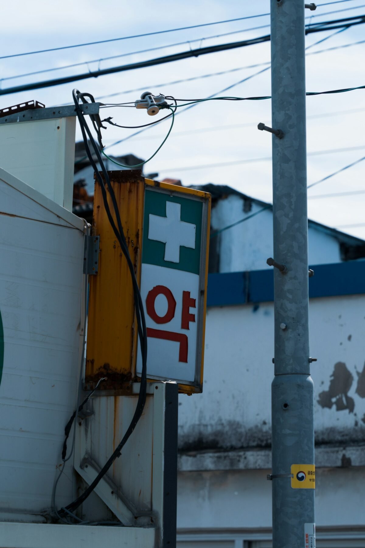 Pharmacy sign in Korea with a green cross, a first stop when you need travel insurance for South Korea