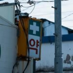 Pharmacy sign in Korea with a green cross, a first stop when you need travel insurance for South Korea