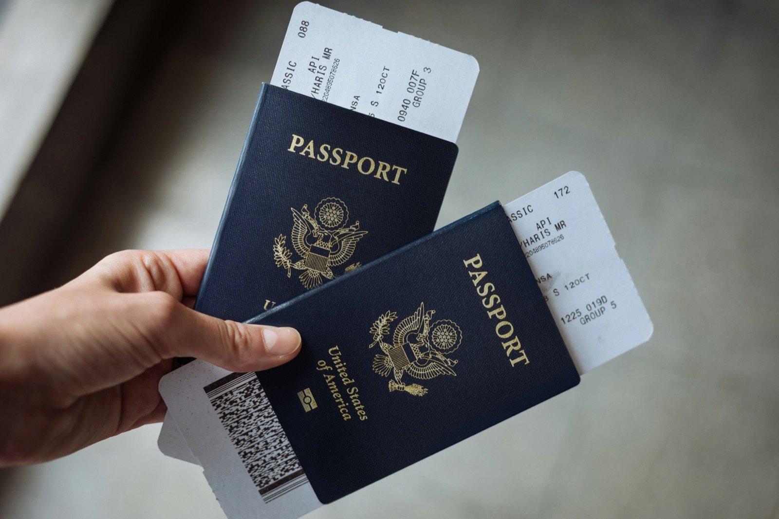 Hand holding two US passports, which you need at the register for an instant tax refund in Korea