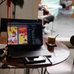 Iced Americano and laptop on a window table inside a modern Seoul cafe