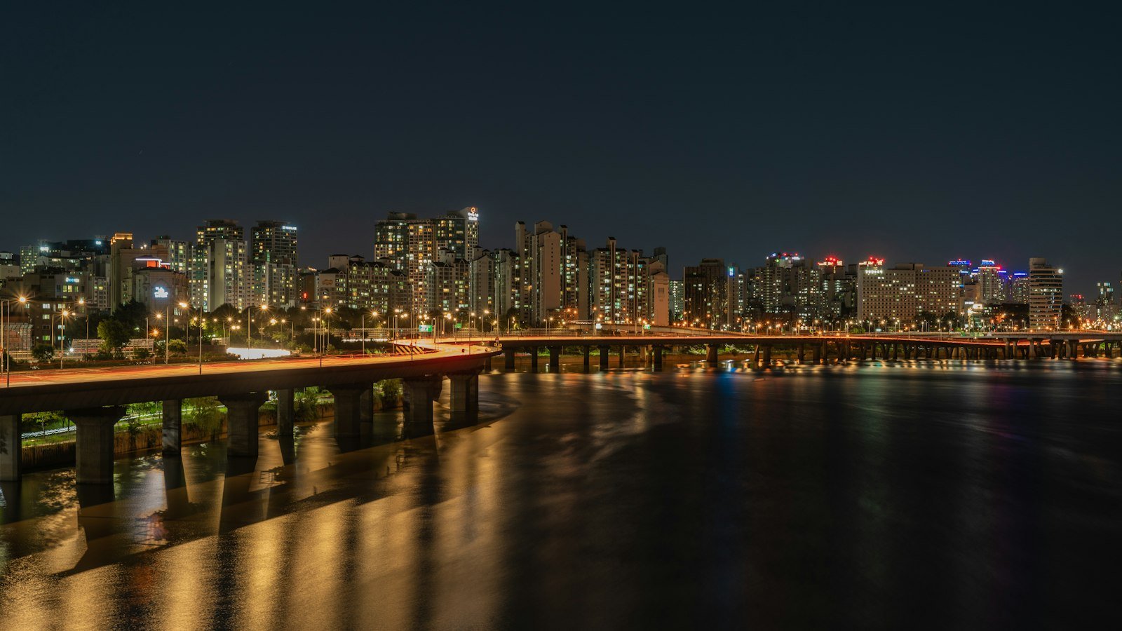 Seoul skyline and a bridge with car light trails at night, when taxi calls are hardest to get