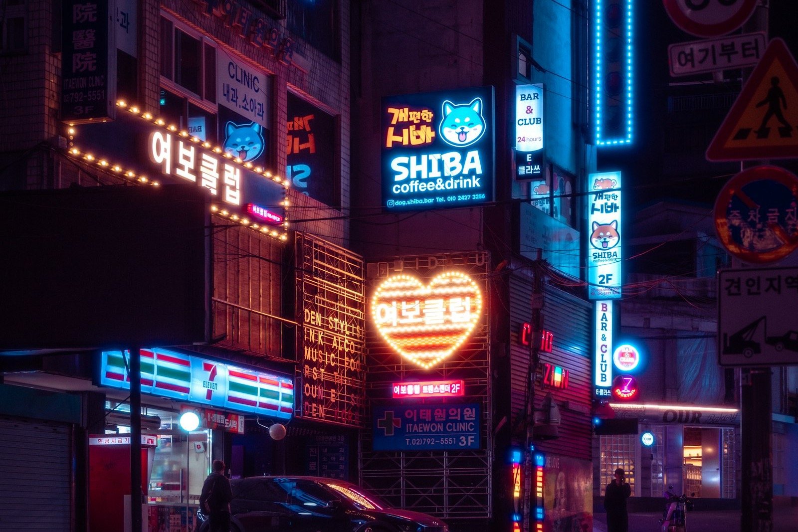 Seoul street at night with a 7-Eleven, a fallback when delivery apps need a Korean number