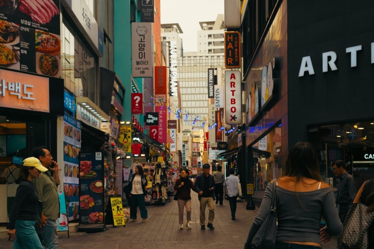 Busy Seoul street lined with shop signs, where learning how to use Naver Map in English helps you find your way