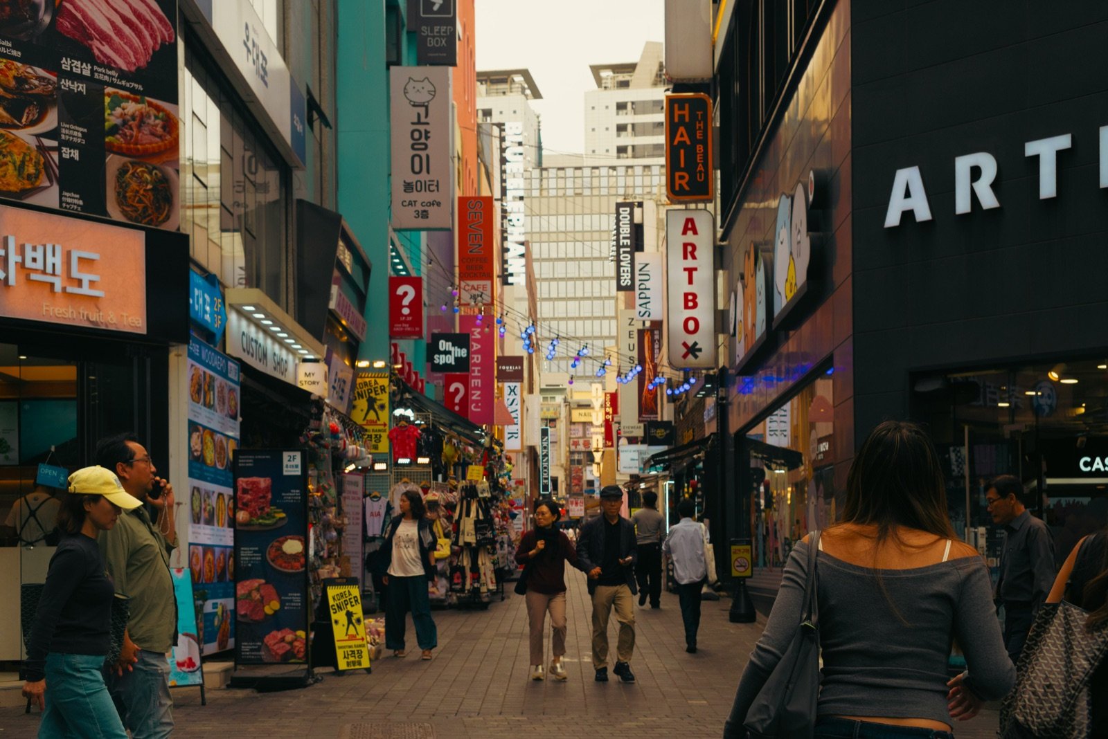 Busy Seoul street lined with shop signs, where learning how to use Naver Map in English helps you find your way