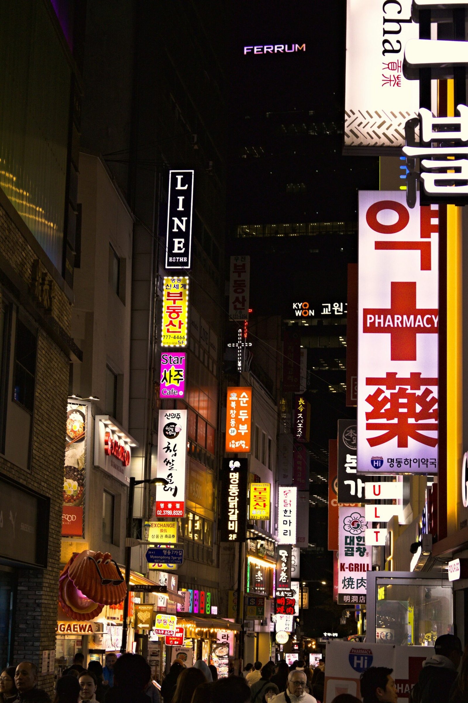 Seoul street at night with pharmacy and clinic signs, where you can find help if you get sick in Korea