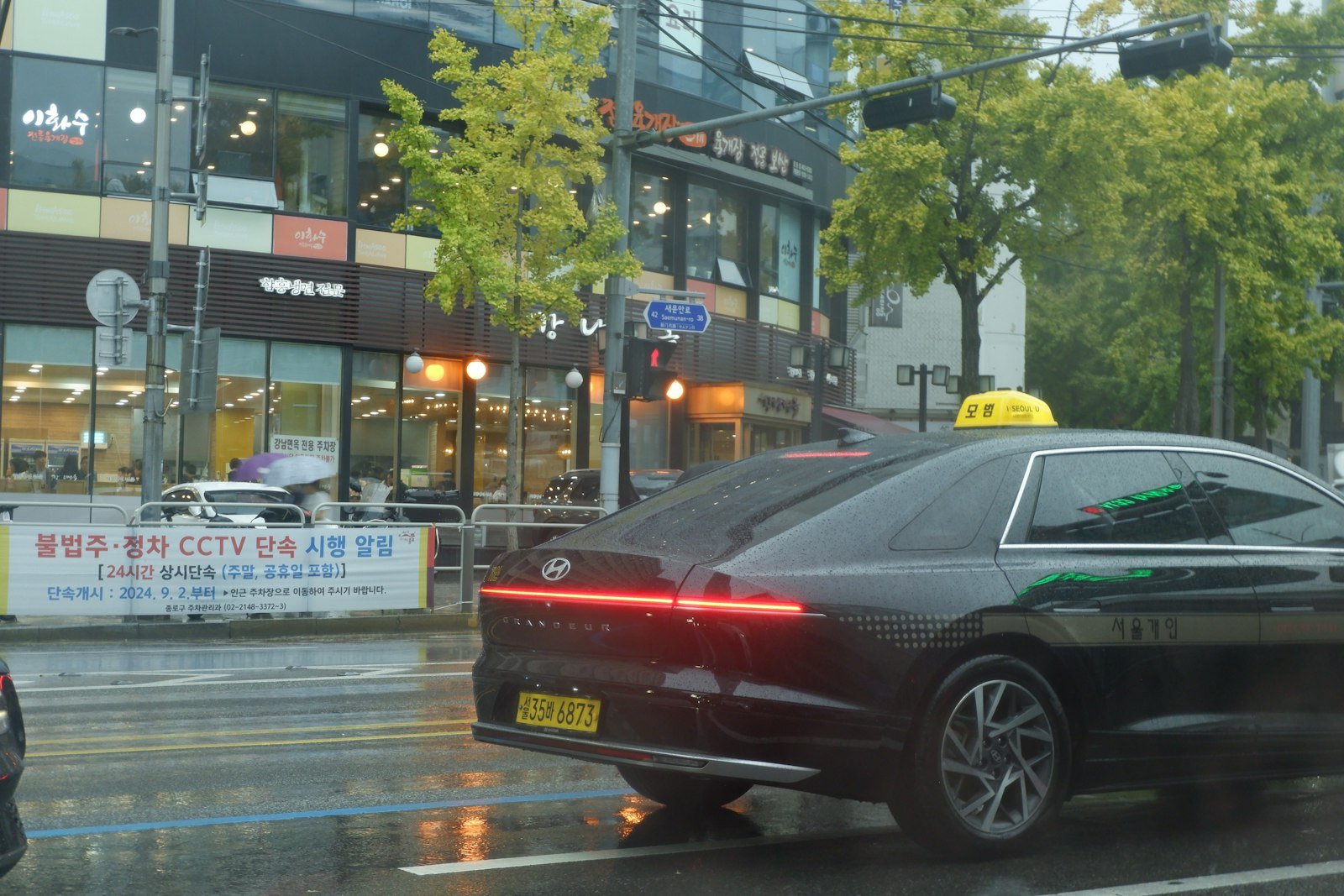 A taxi on a rainy street in Seoul, where tipping drivers isn't expected